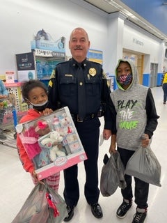 image of a cop posing with 2 kids