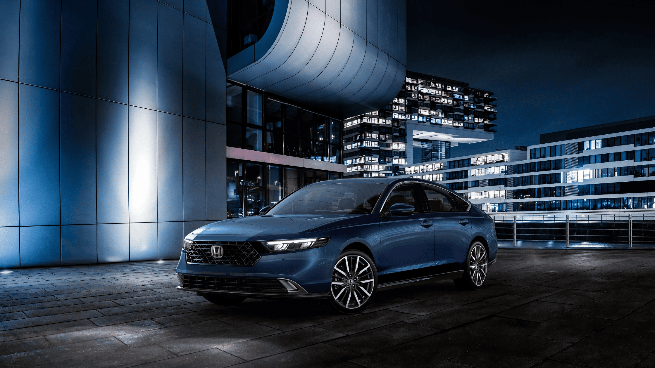 2024 Honda Accord Sedan in blue parked in a modern urban setting at night.